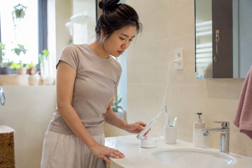 Người dùng kiểm tra bàn chải điện không sạc tại lavabo