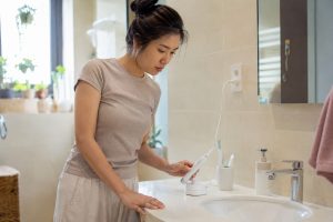 Người dùng kiểm tra bàn chải điện không sạc tại lavabo